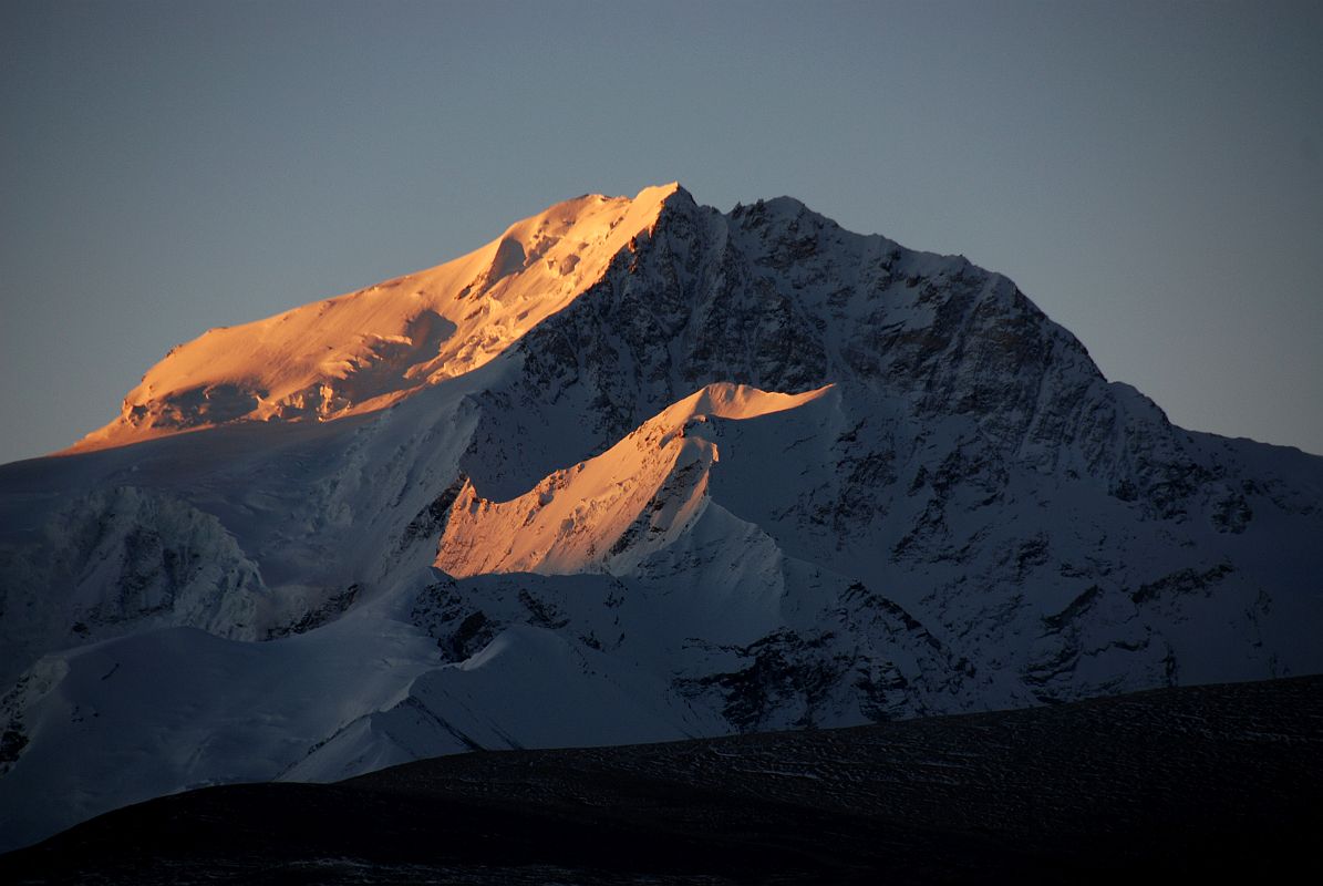 09 Shishapangma East And North Faces And Yebokangal Ri At Sunrise From Shishapangma North Base Camp Shishapangma East Face shines at sunrise from Shishapangma North Base Camp (5029m). The peak with the sun�s rays just below the Shishapangma North Face is Yebokangal Ri (7365m, Jebo Kangri), which was first climbed by Jerzy Kukuczka and Artur Hajzer on August 29, 1987.